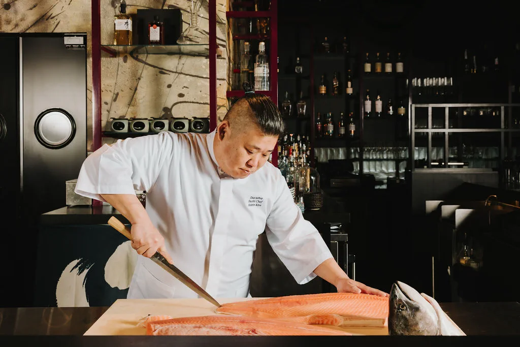 Chef James Kim preparing a whole salmon at The Naisho Room